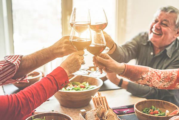 A group of seniors toasting with wine glasses